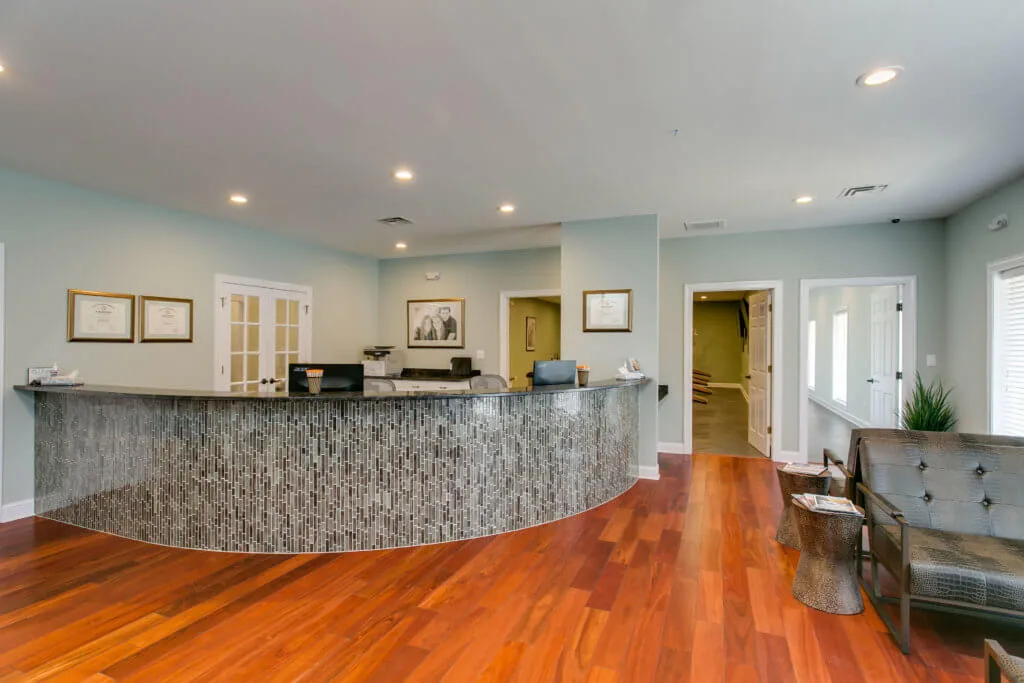 NC Oral Surgery + Orthodontics office in Dunn, NC with cherry hardwood floors interior and light gray checkin desk