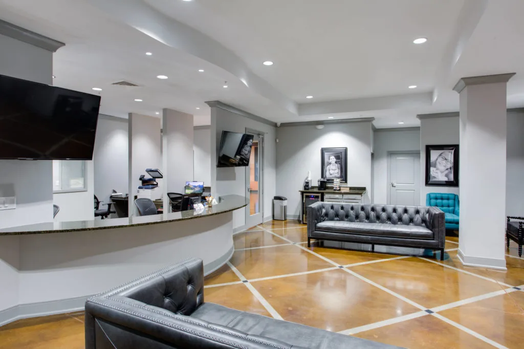 Cary Orthodontist interior Lobby area with gray leather couches and beautiful concrete floor